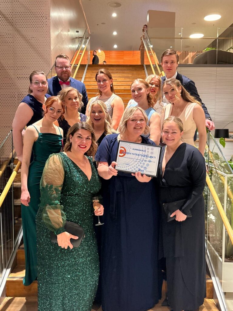 Projektitiimi kunniakirjan kanssa